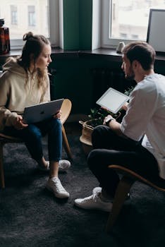 Two adults having a tech-focused discussion in a cozy home setting.