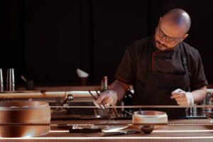 A chef skillfully prepares food using chopsticks in a restaurant kitchen with a bamboo steamer.