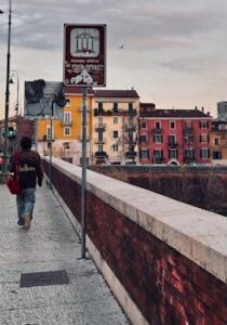 A picturesque street scene in Verona with colorful buildings and sunset sky.