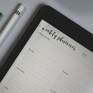 Top view of a digital tablet with weekly planner layout and stylus pen, ideal for organization.